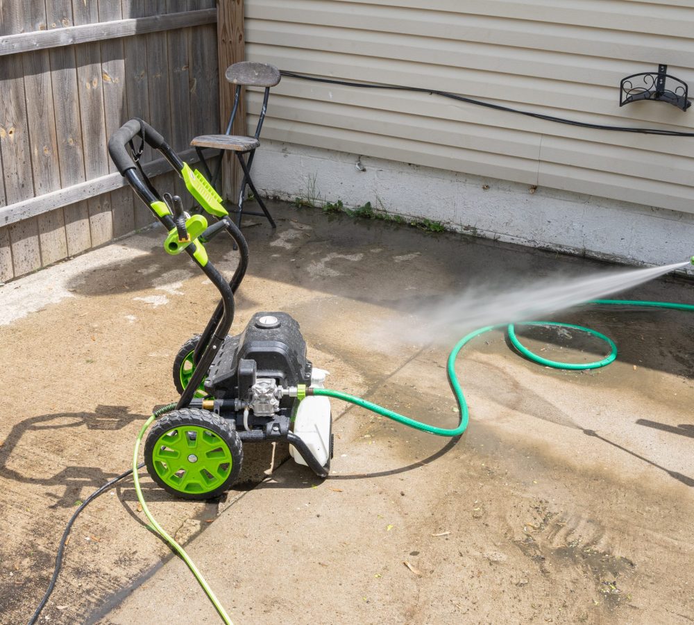 pressure washer is spraying high pressure water to clean dirt an pressure washer cleans the patio with high pressure water spray